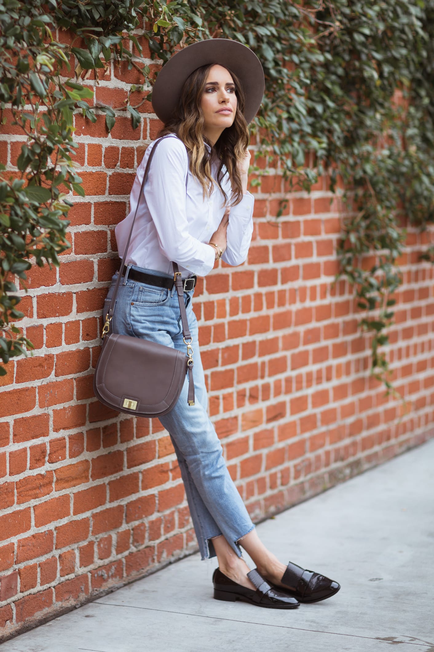 Louise Roe wearing Brahmin crossbody bag with jeans and white shirt