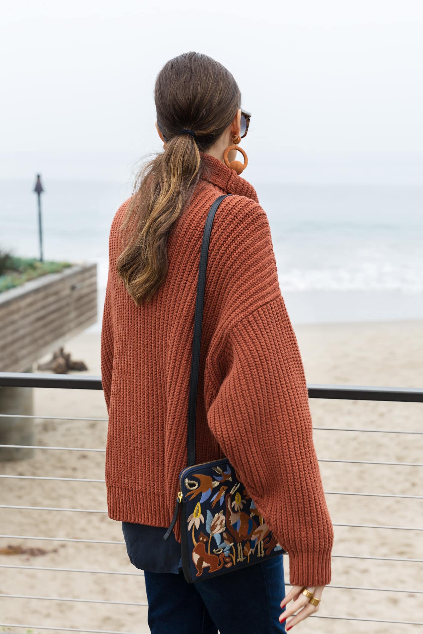 Louise Roe Talks About Self Love Wearing Free People Turtleneck Madewell Jeans Rebecca De Ravenel Earrings and Embroidered Clutch